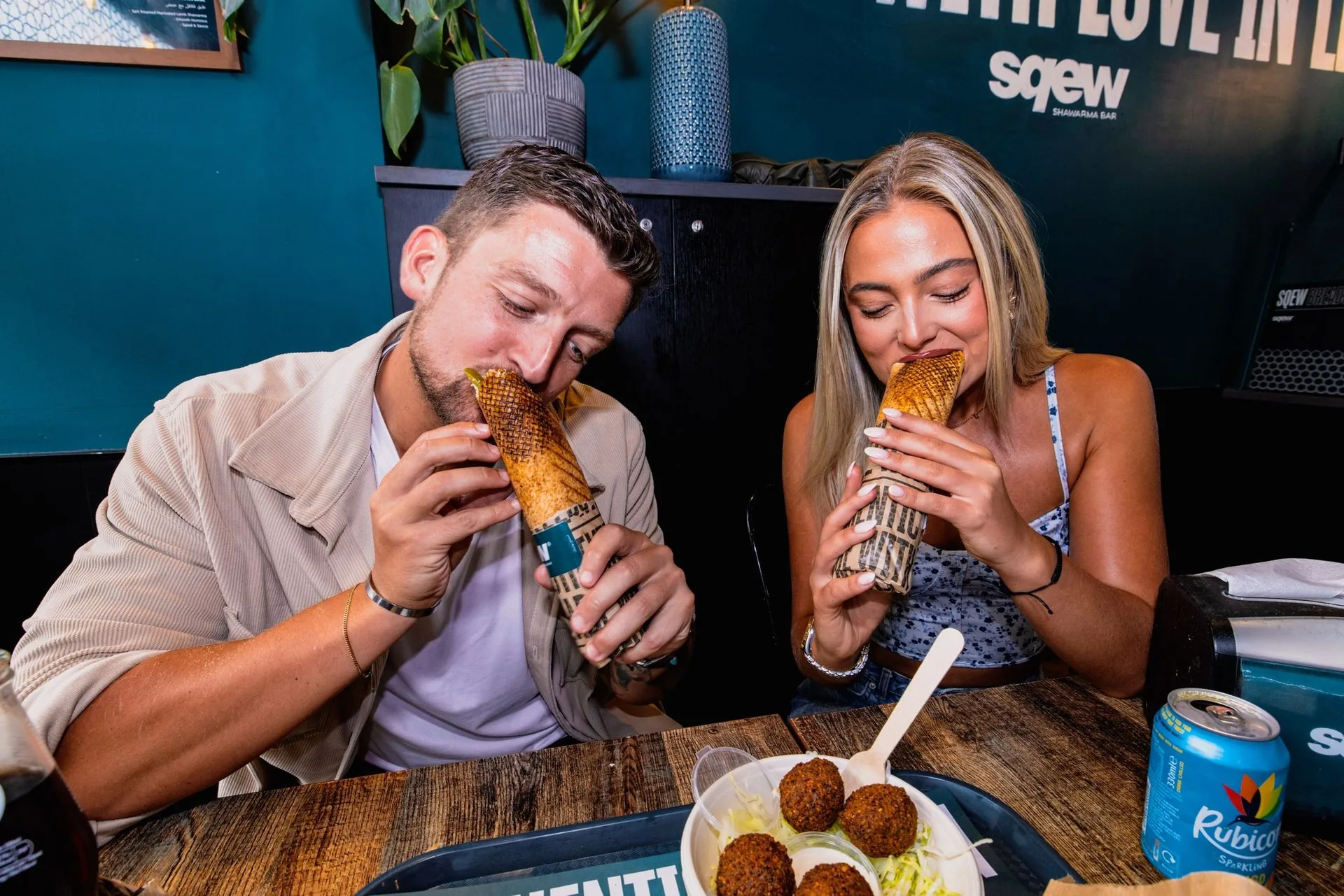 Two customers enjoying Sqew shawarma wraps